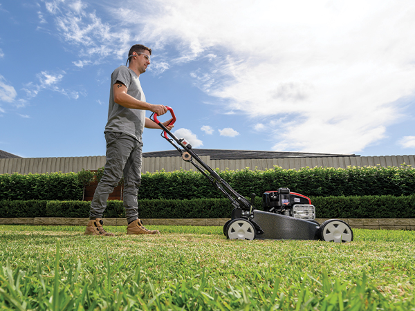 Man cutting grass with lawn mower